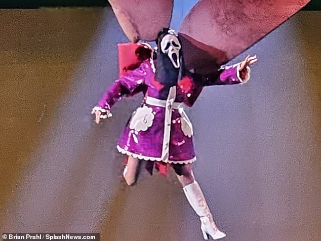 Spooky: Katy wore a scream mask as she dangled in the air for the spooky show