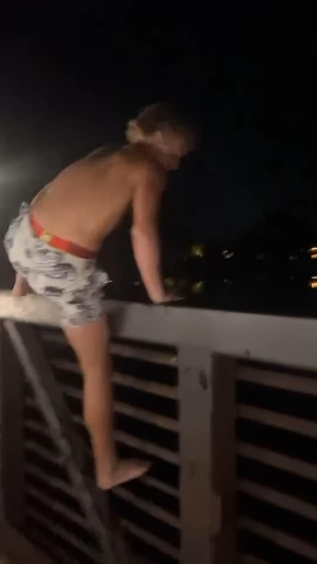 The children cheered on the gasoline-covered boy as he climbed the railing before his backflip