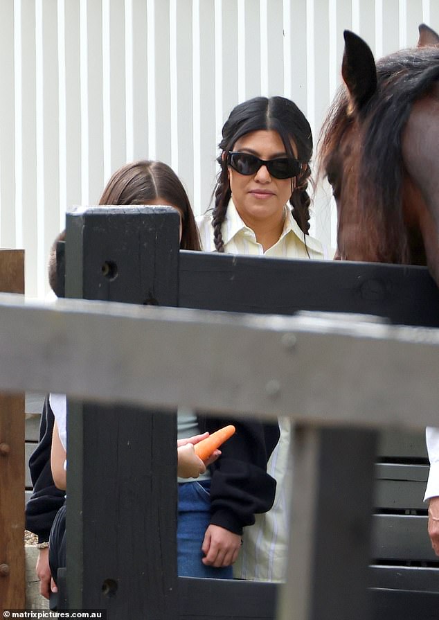Kourtney smiled at her daughter as she fed the horse carrots during the day
