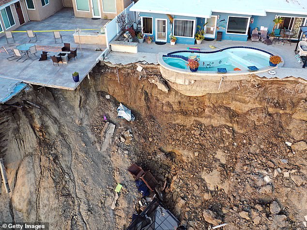 An aerial view of a remaining pool on the edge of a hillside landslide caused by heavy rainfall that resulted in four oceanfront residential buildings being evacuated and closed due to unstable conditions, March 16, 2023 in San Clemente, California